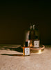 Oud Attar bottles resting under a glass cloche in low light