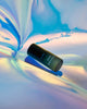 Dark Oud Delight mini bottle on an iridescent rain-blue backdrop