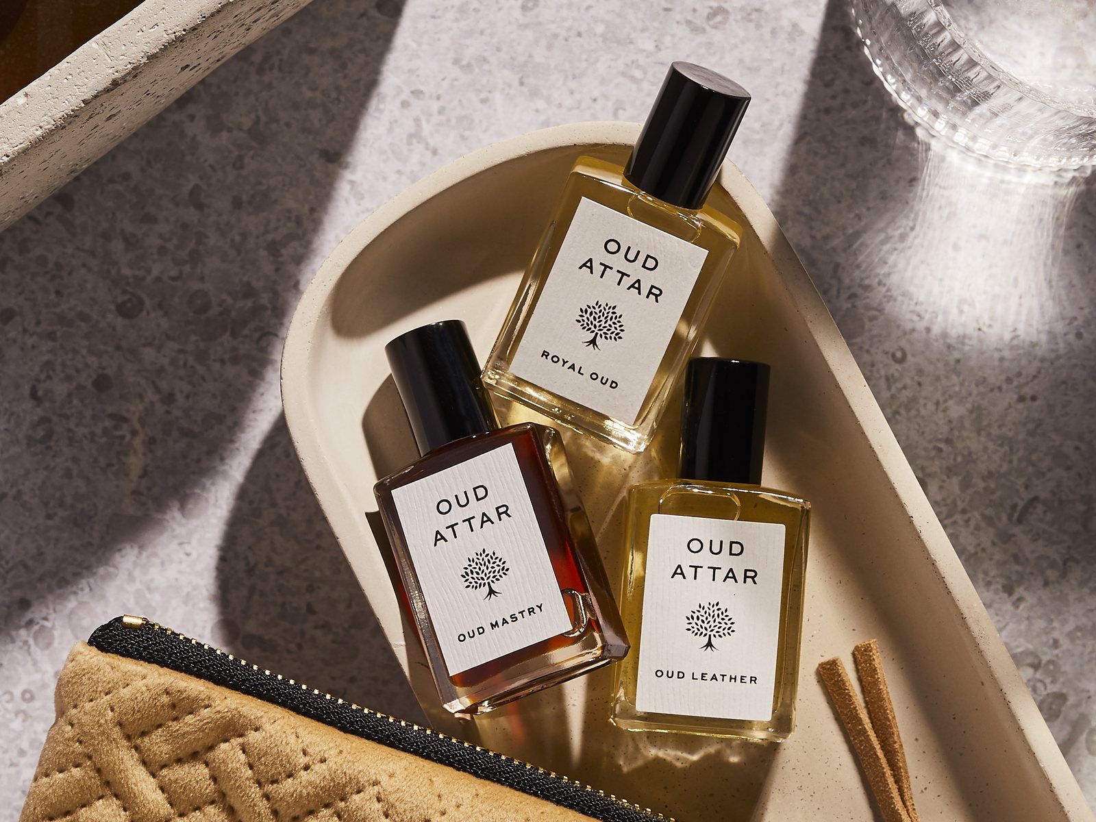 Three Oud Attar perfume oils tucked into a zipped pouch, ready for the morning