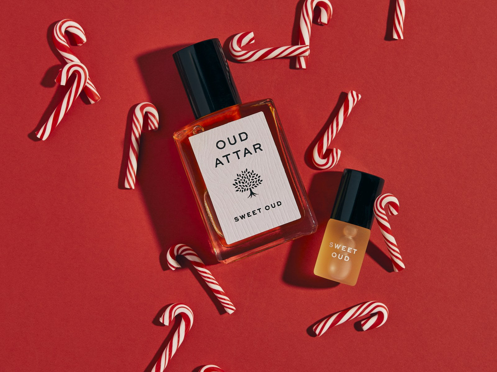 Oud rollerballs with candy canes on red