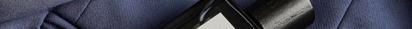 Royal Oud perfume oil tucked into the pocket of a navy jacket