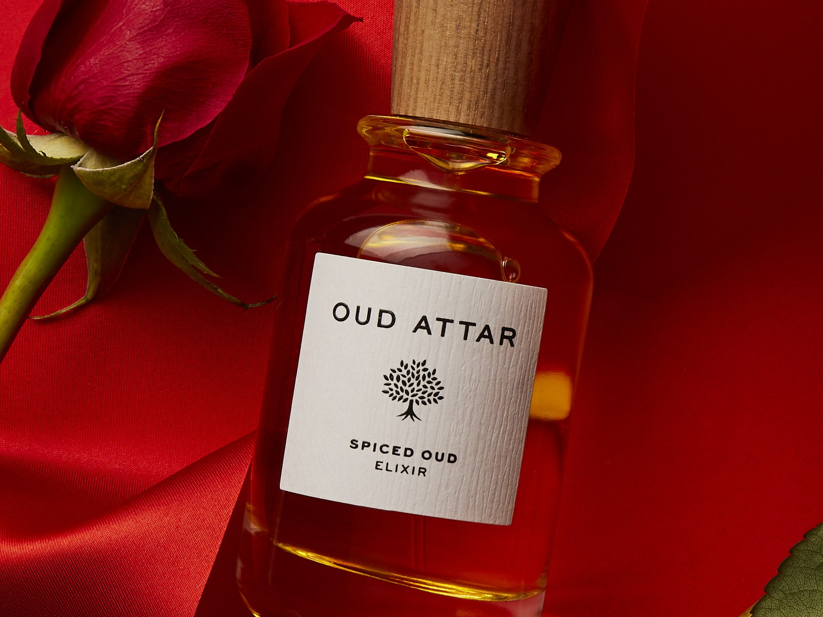 Spiced Oud elixir with red roses on red silk