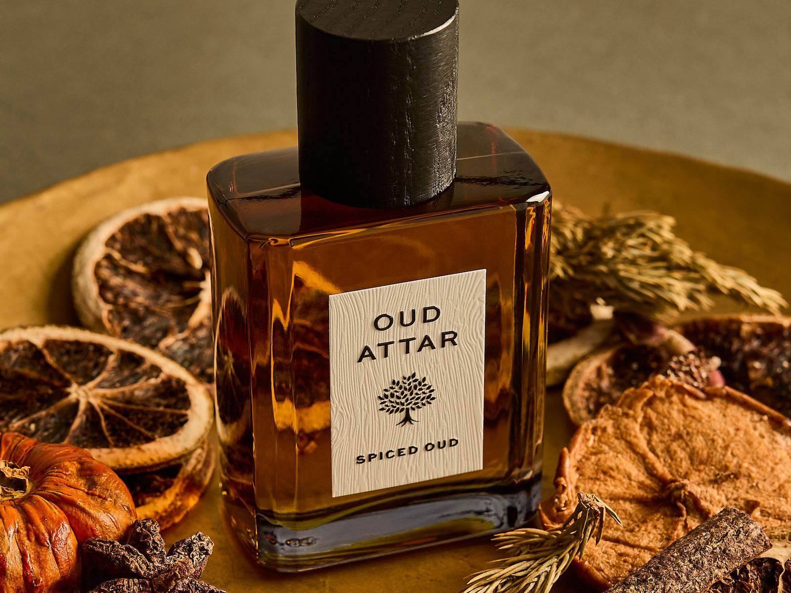 Spiced Oud perfume oil among dried orange slices, star anise and cinnamon